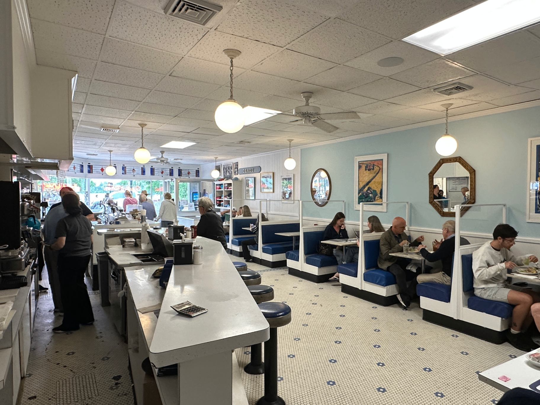 Inside Candy Kitchen — red vinyl swivel stools at the Formica counter