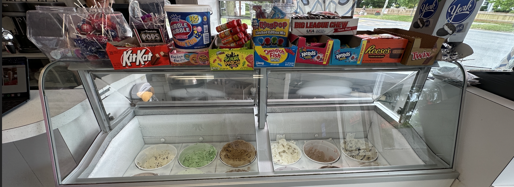 Candy Kitchen ice cream freezer topped with KitKat, Sour Patch, Nerds, Reese's, Twix, Ring Pops, and Big League Chew